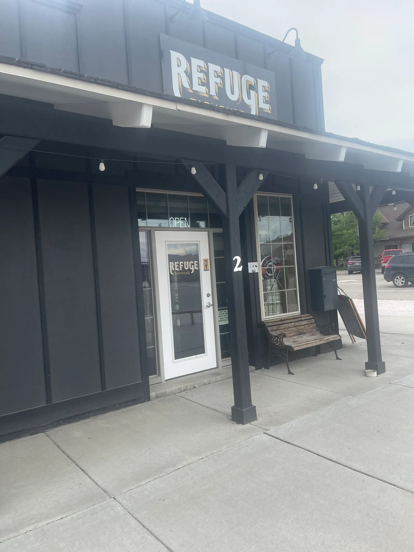 The front door of Refuge Taphouse under the REFUGE sign